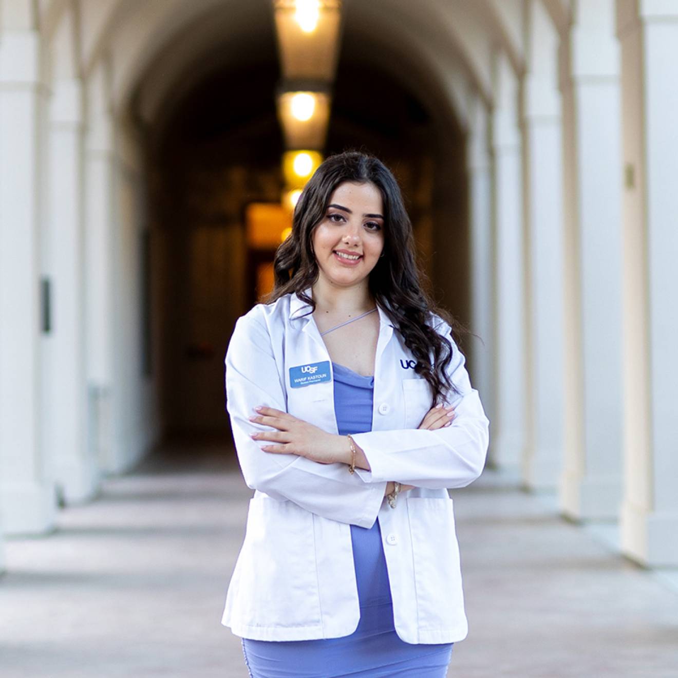 A smiling woman in a white doctor's coat