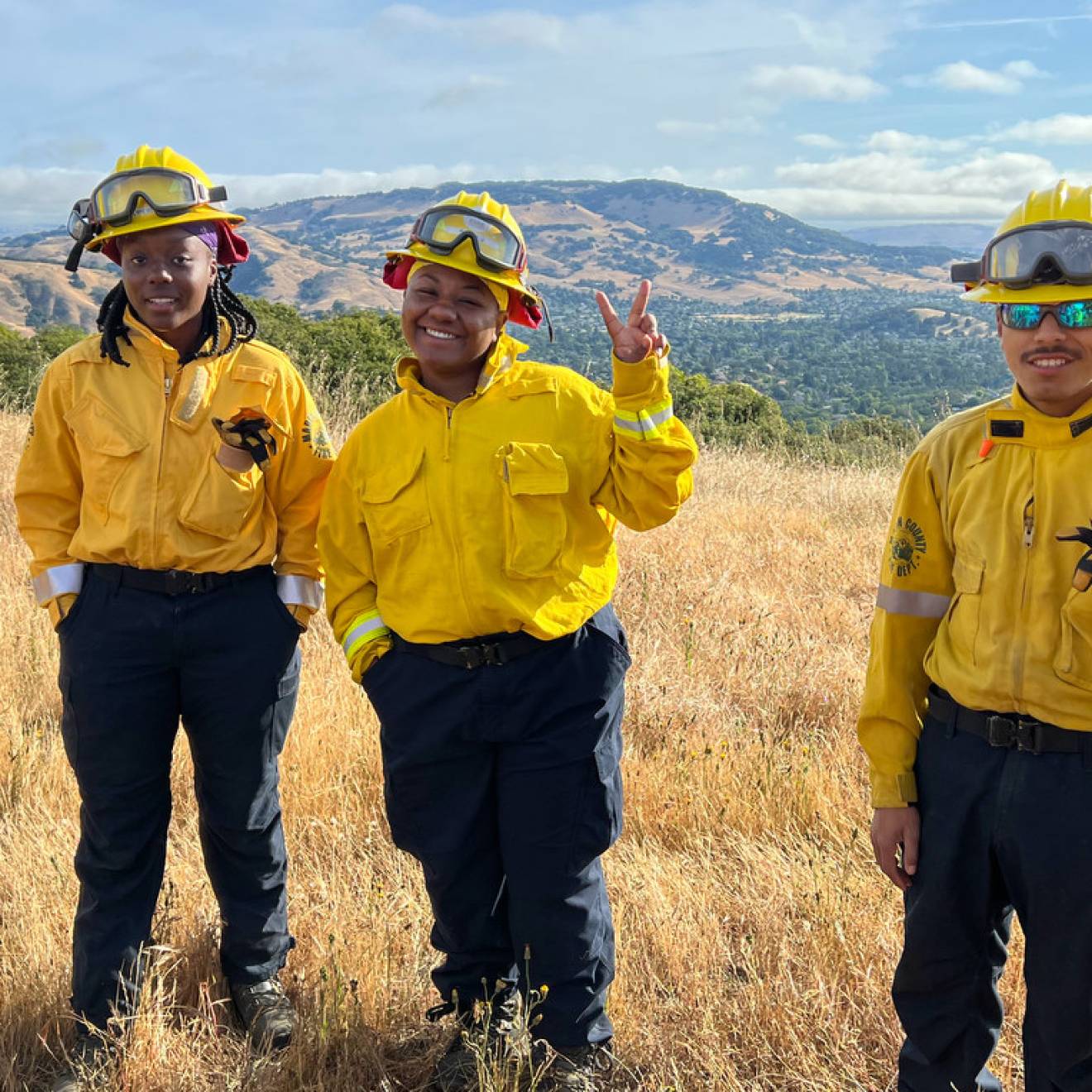 Young African American and Latino firefighters smile at camera