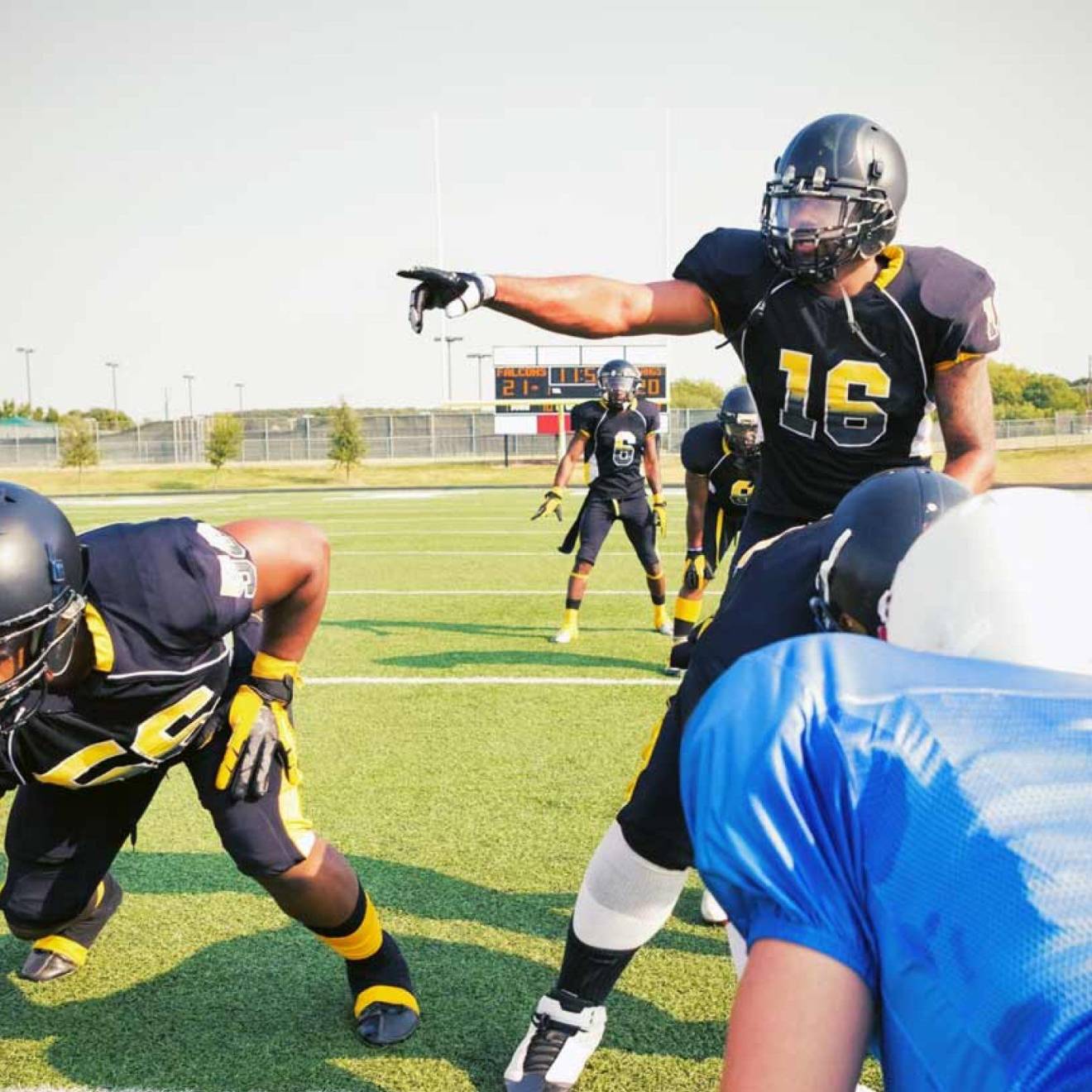 A quarterback points over an offensive line during a football game