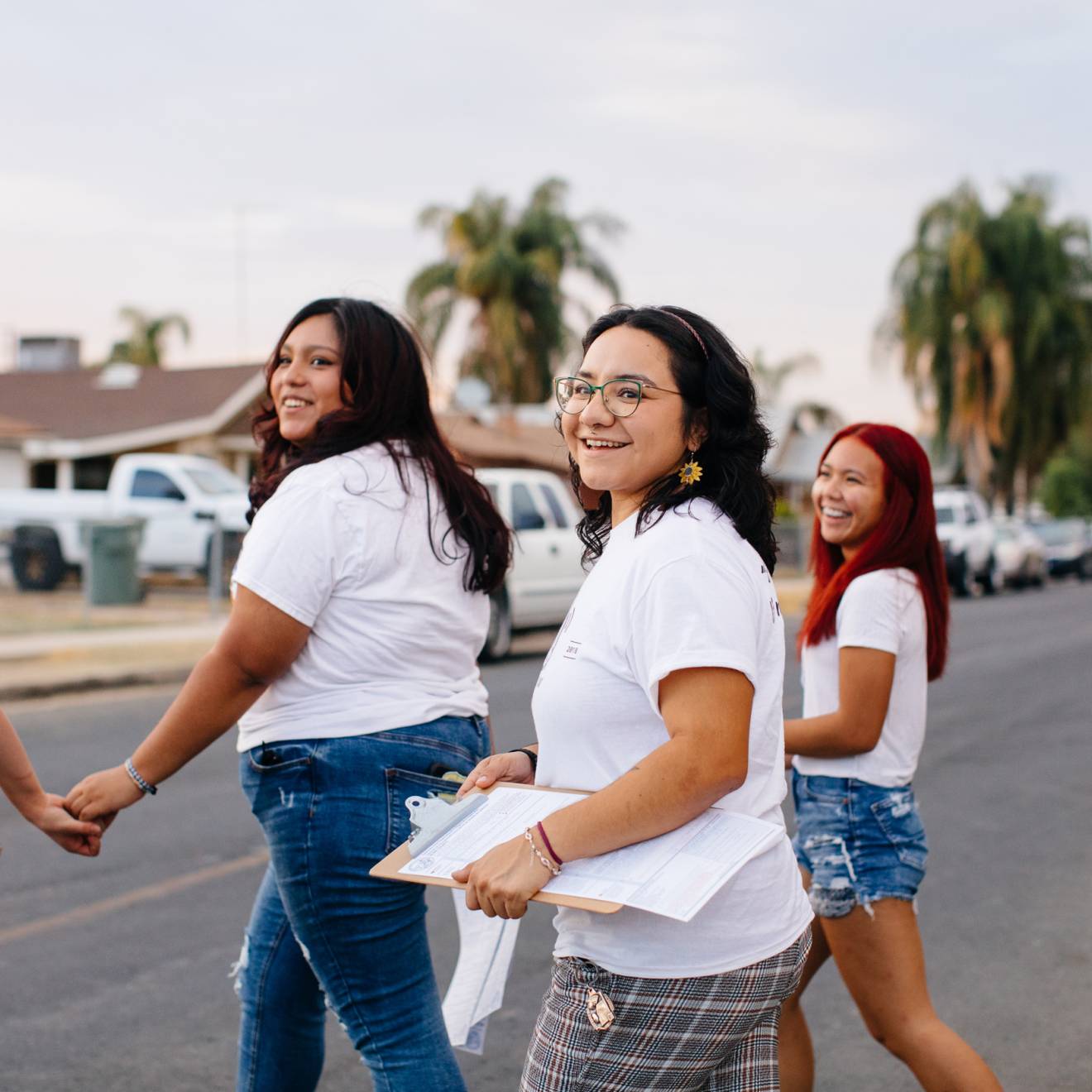 Four young women walking around a neighborhood in Delano doing voter registration
