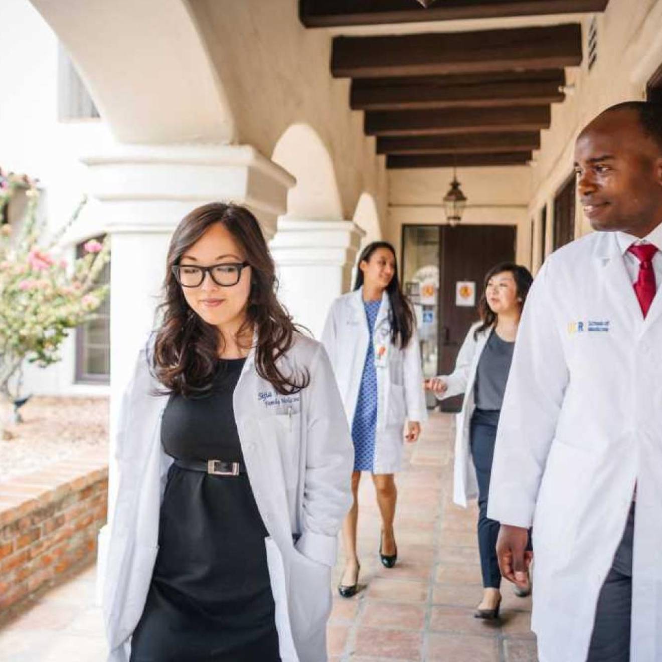 Doctors walking along a breezeway wearing white coats