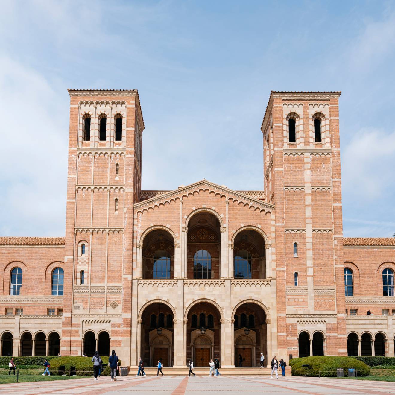 UCLA Royce Hall, a light brick building with two towers, against a slightly cloudy bright blue sky