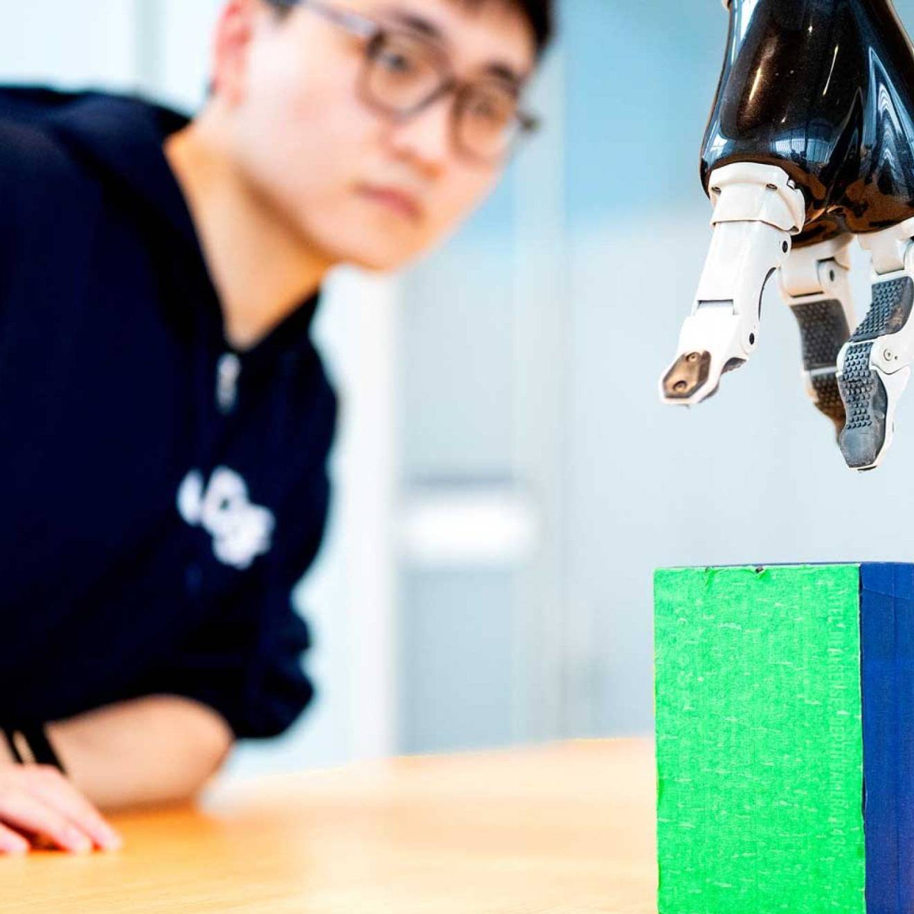 a researcher working with a robotic arm