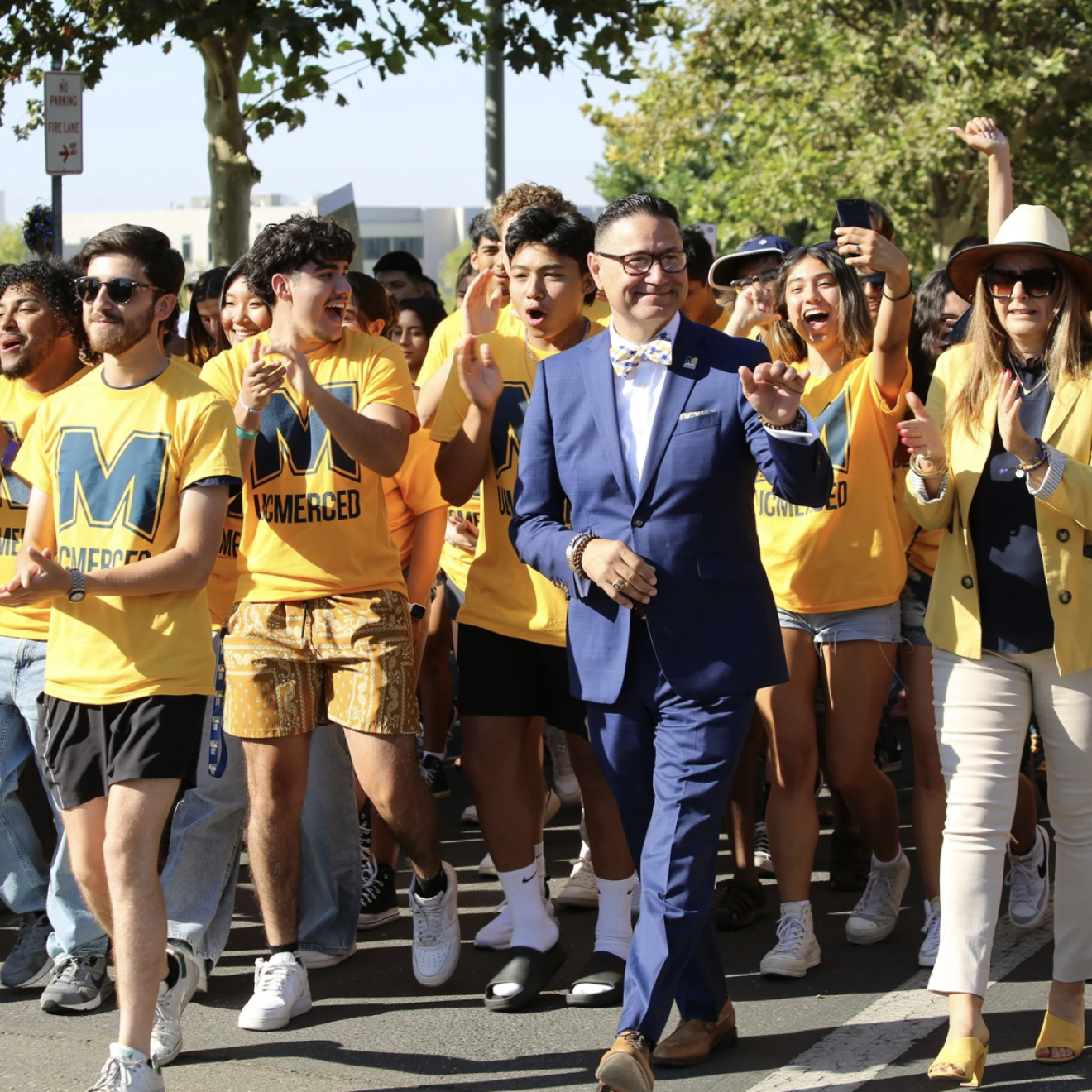 Chancellor Muñoz leads a group of students in yellow T-shirts