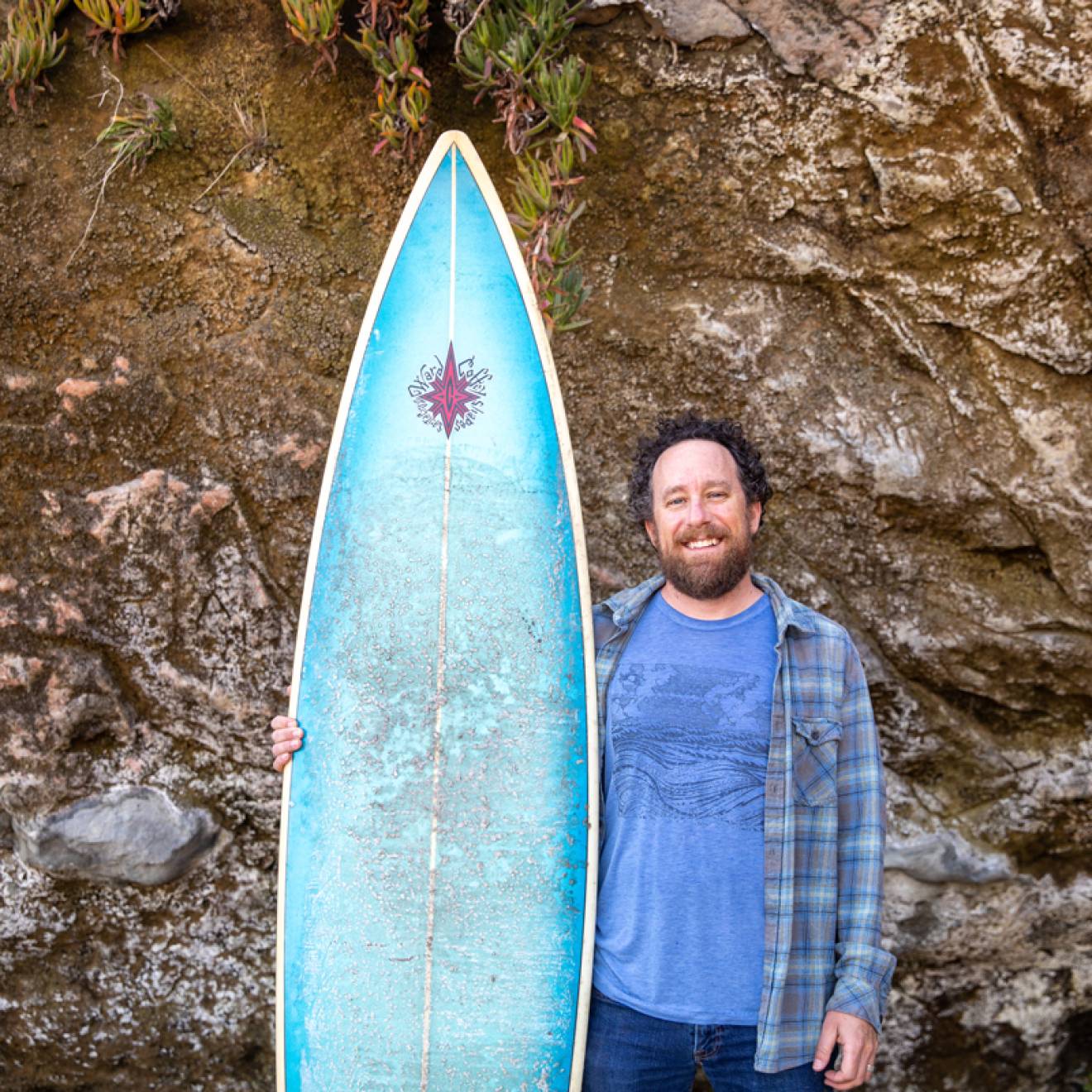 David Schulkin stands with his surfboard