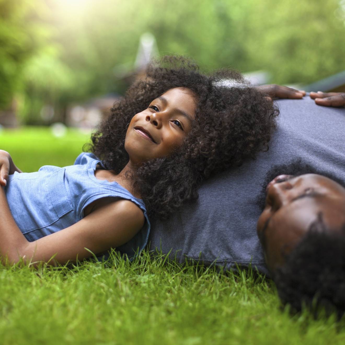 Going offline A young girl reclines against her father's shoulder on fresh grass
