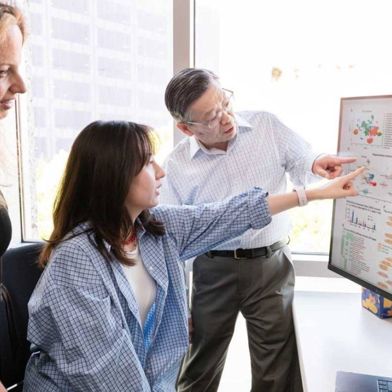 Alzheimer's advance Three people in an office look at a large screen next to another large screen