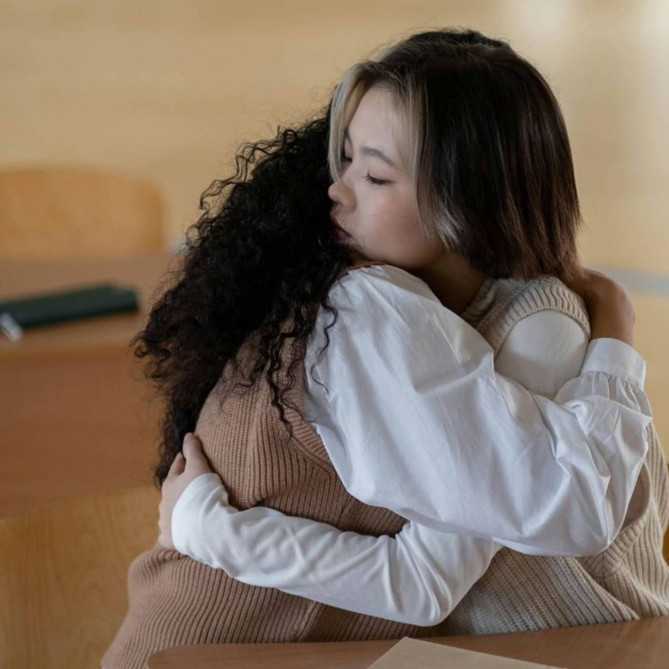 Two young people hug each other solemnly