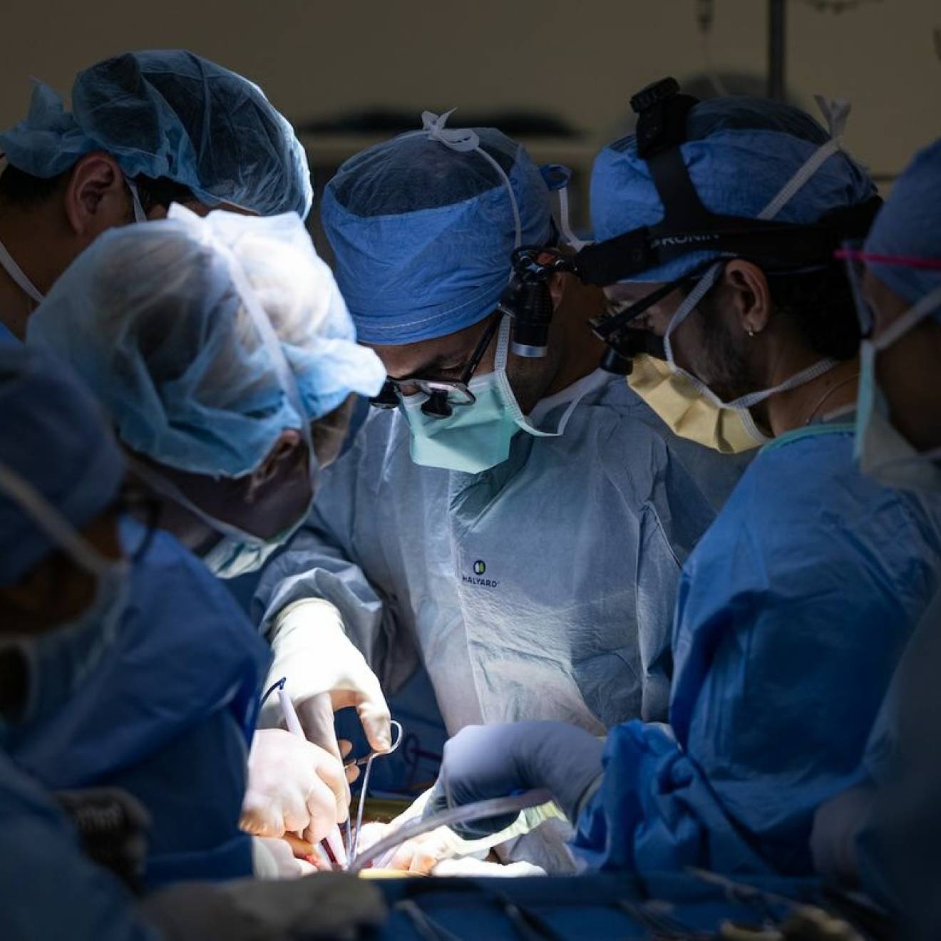 First bladder transplant Six surgeons huddle around someone while operating