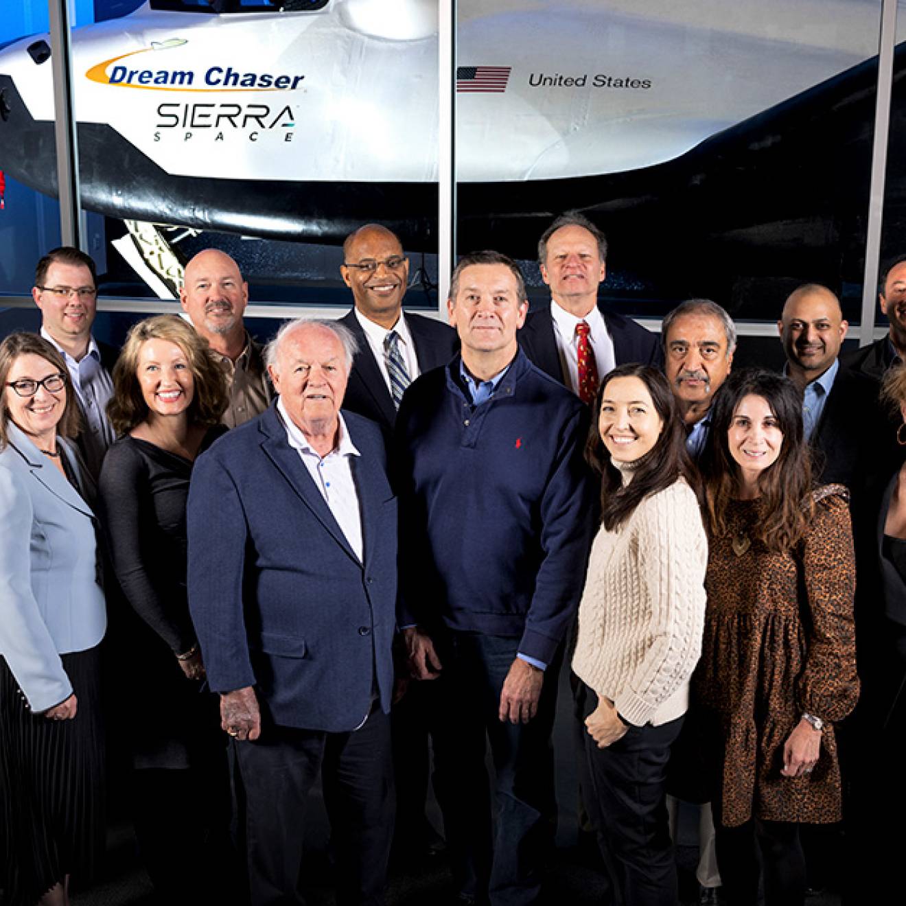 Group photo in front of a space vehicle
