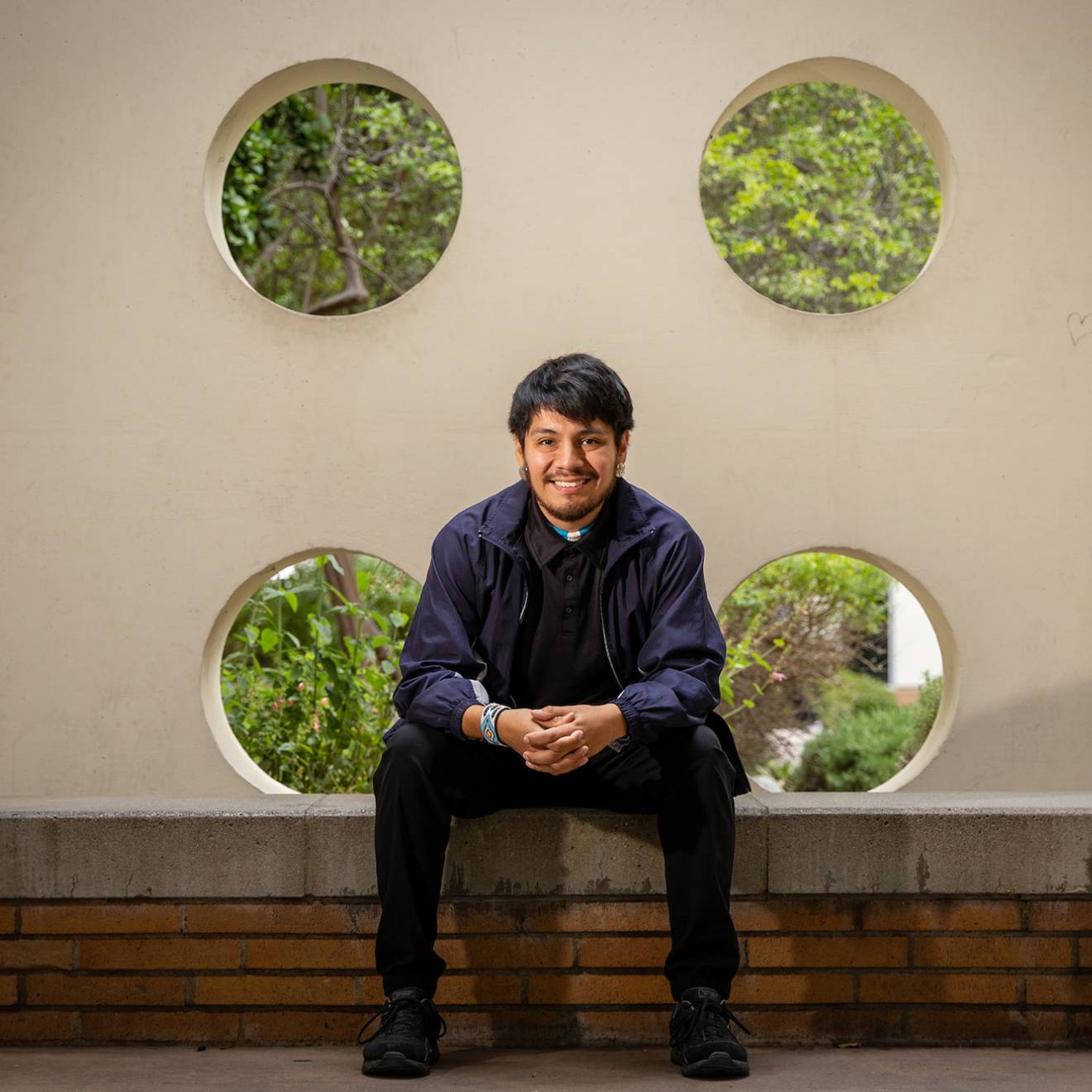 A smiling man sitting on a bench