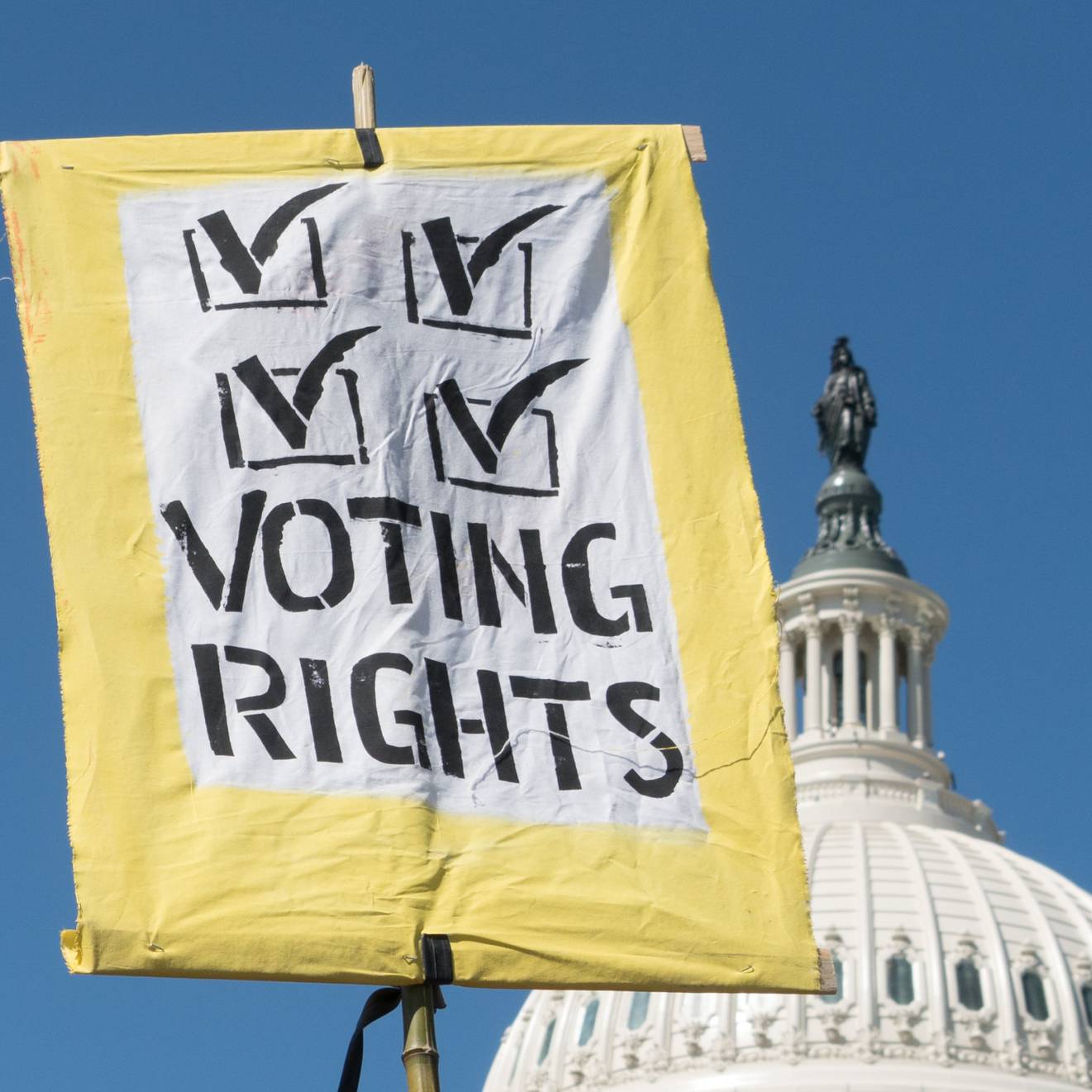 A voting rights sign held up in front of the U.S. Capitol