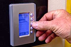 hand adjusting a thermostat